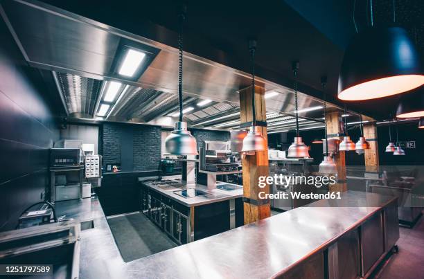 interior of illuminated commercial kitchen in restaurant - empty kitchen stock pictures, royalty-free photos & images