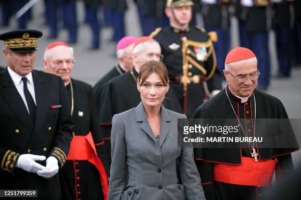 French first lady Carla Bruni-Sarkozy is accompanied by Vatican Secretary of State Tarcisio Bertone upon the arrival of Pope Benedict XVI at Orly...