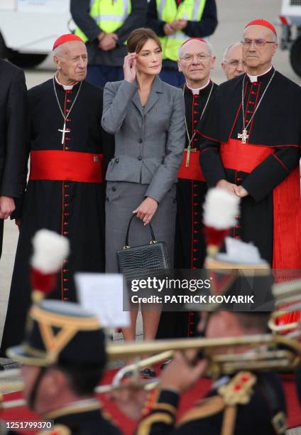 French first lady Carla Bruni-Sarkozy and Vatican Secretary of State Tarcisio Bertone listen to the anthems upon the arrival of Pope Benedict XVI at...