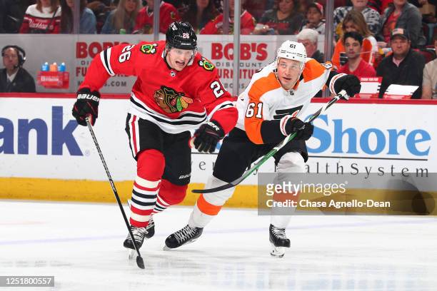 Austin Wagner of the Chicago Blackhawks and Justin Braun of the Philadelphia Flyers watch for the puck in the first period at United Center on April...