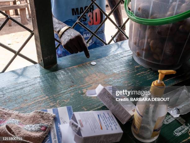 Client buys one tablet of paracetamol to Antoine Bissa, a nurse and the owner of a street pharmacy, in Bangui, on February 21, 2022. Informal...