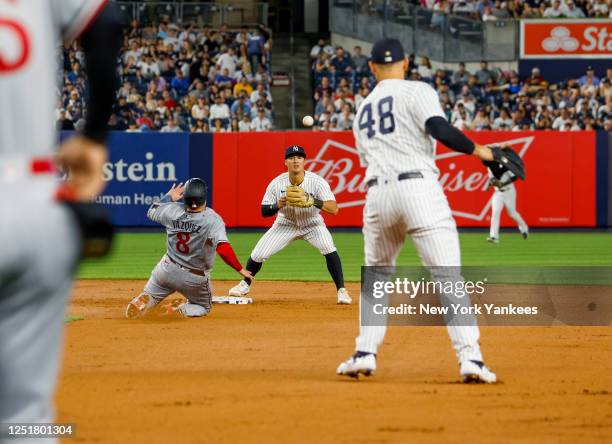Anthony Rizzo throws to Anthony Volpe of the New York Yankees to complete an out during a game against the Minnesota Twins at Yankee Stadium on April...