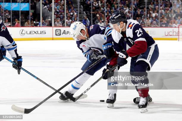 Neal Pionk of the Winnipeg Jets skates against Nathan MacKinnon of the Colorado Avalanche at Ball Arena on April 13, 2023 in Denver, Colorado.