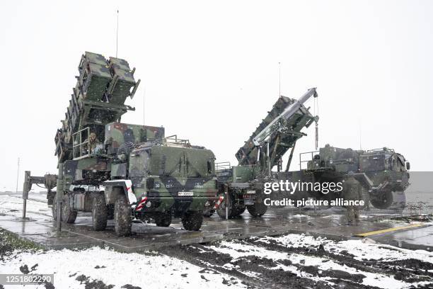 April 2023, Poland, Miaczyn: Bundeswehr soldiers work on a crane between trailers with launchers for guided missiles of the Patriot air defense...