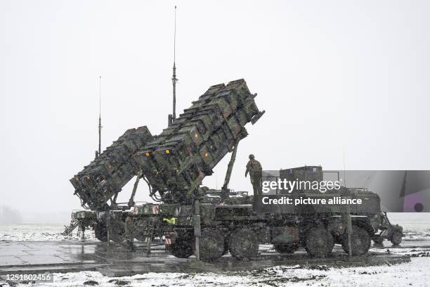April 2023, Poland, Miaczyn: Soldiers of the German Armed Forces stand on a trailer with launching pads for guided missiles of the Patriot air...