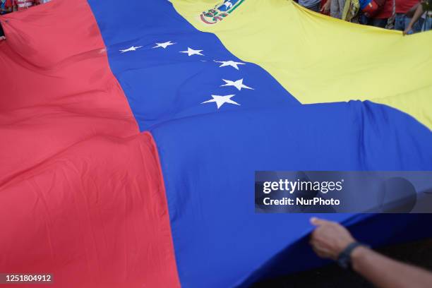 Man holds a Venezuelan flag during a march to commemorate the 21st anniversary of Hugo Chavez's return to the presidency after the coup against him...