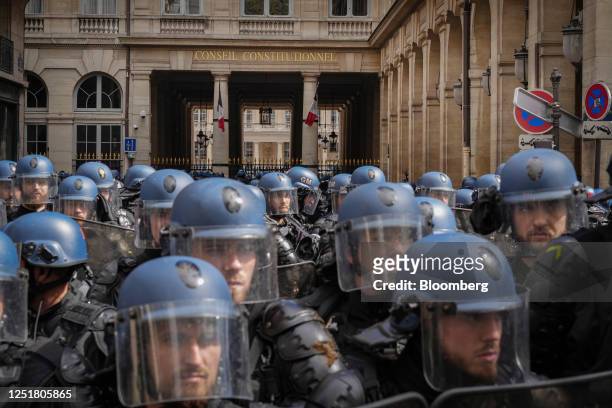 Riot police guard the Constitutional Council building during a demonstration against pension reform in central Paris, France, on Thursday, April 13,...