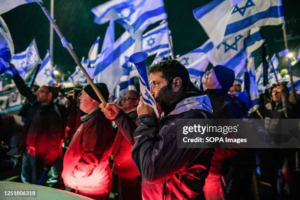 Anti reform protestors wave the Israeli flags and use the vuvuzelas to make noise during the demonstration. Pro and Anti-judicial reform protesters...