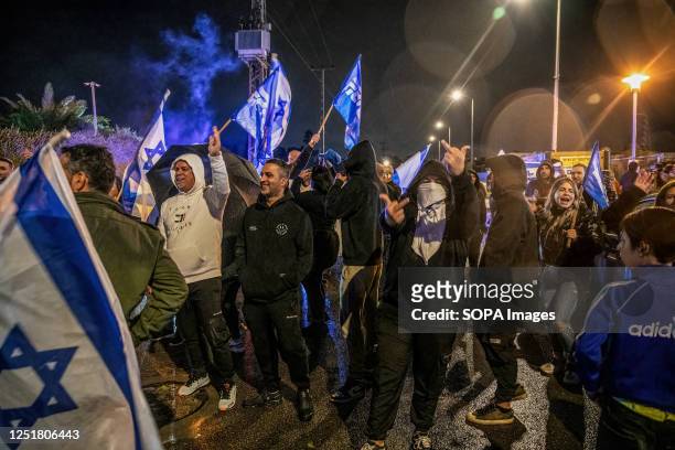 Right-wing protesters hold Likud party flags and gesture at anti-reform protesters during the demonstration. Pro and Anti-judicial reform protesters...
