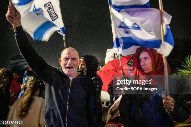 Anti reform protesters wave Israeli flags and hold signs in the rain during the demonstration. Pro and Anti-judicial reform protesters demonstrated...