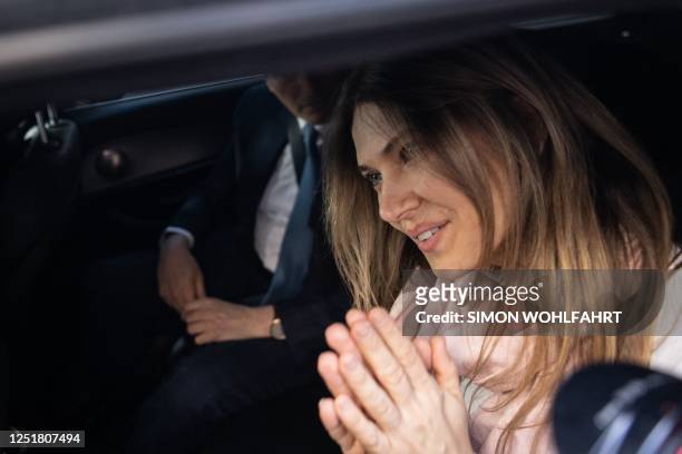 Greek MEP Eva Kaili smiles in the back of a vehicle arrives at her home in Brussels upon her release from Haren prison, in Brussels on April 14,...