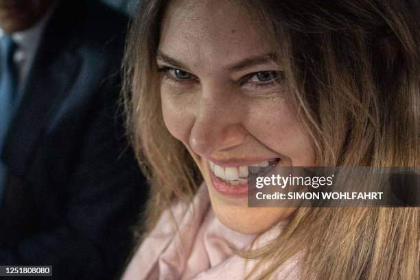 Greek MEP Eva Kaili smiles in the back of a vehicle arrives at her home in Brussels upon her release from Haren prison, in Brussels on April 14,...