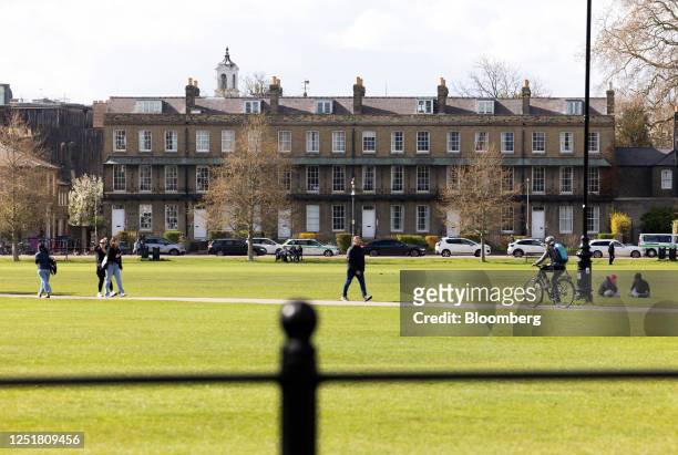 Row of residential terraced houses bordering a green in Cambridge, UK, on Thursday, April 13, 2023. Cambridge is a crucial part of the UK's goal to...