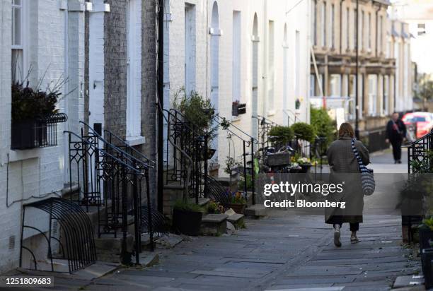 Pedestrian passes a row of residential terraced houses in Cambridge, UK, on Thursday, April 13, 2023. Cambridge is a crucial part of the UK's goal to...