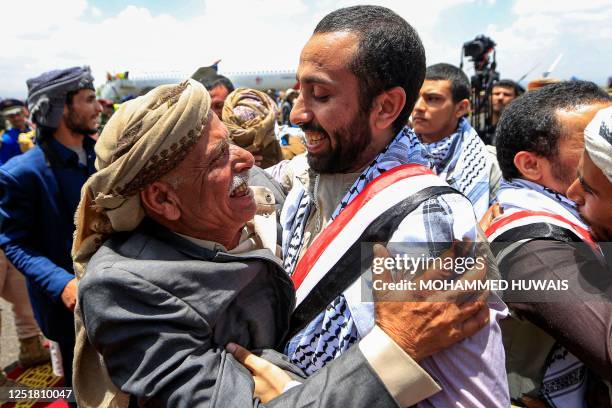 An elderly man embraces one of the returned Huthi prisoners exchanged in a deal Yemen's internationally recognised-government upon arrival at Sanaa...