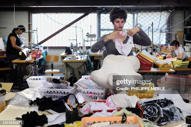 Deux ex-ouvrières du fabricant de lingerie Lejaby travaillent avec une stagiaire comme couturières dans un atelier, le 26 avril 2011, à...