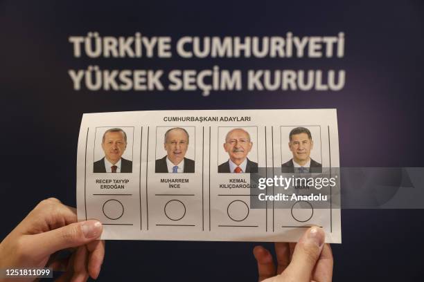 Person holds the ballot displaying presidential candidates in front of a text translating "Supreme Election Council of Republic of Turkiye" ahead of...