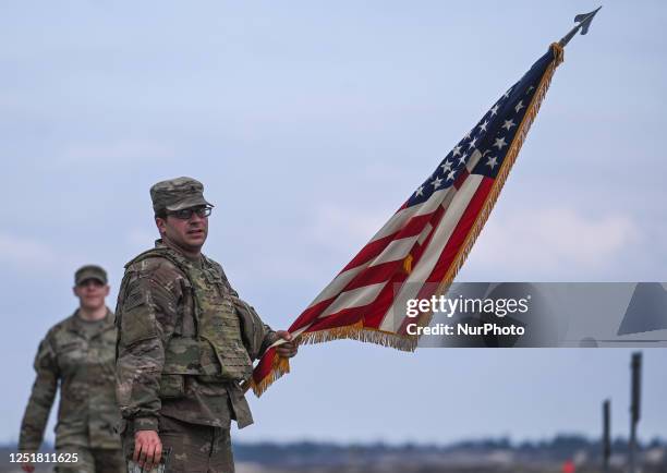 Soldier from the 1st Infantry Division hold the U.S. Flag at the end of a military training at Nowa Deba training ground, in Nowa Deba, Poland, on...