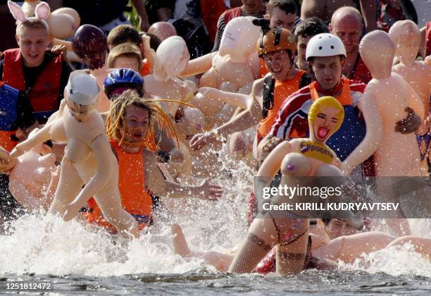 Russian men and women participate in the "Bubble Baba Challenge" blow-up sex doll swimming race on the river Vuoksa in Losevo village, some 110 kms...