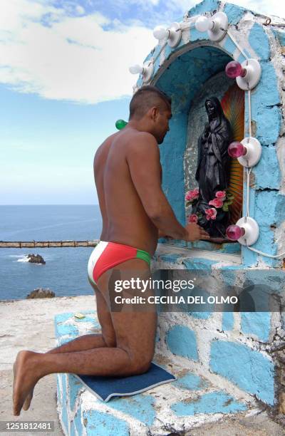 Cliff diver prays before jumping from "La Quebrada" cliff in Acapulco, Mexico, on September 30th, 2007. The tradition of "La Quebrada" goes back to...