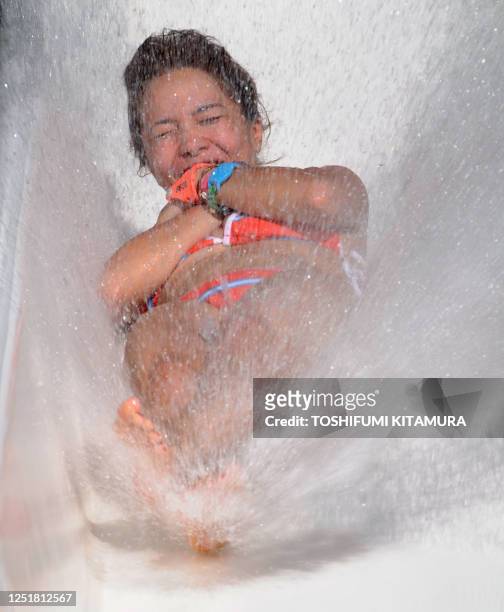 Girl enjoys the water slide to beat the heat at one of the Toshimaen swimming pools in Tokyo on July 26, 2009. Some 16,000 people came out to pack a...