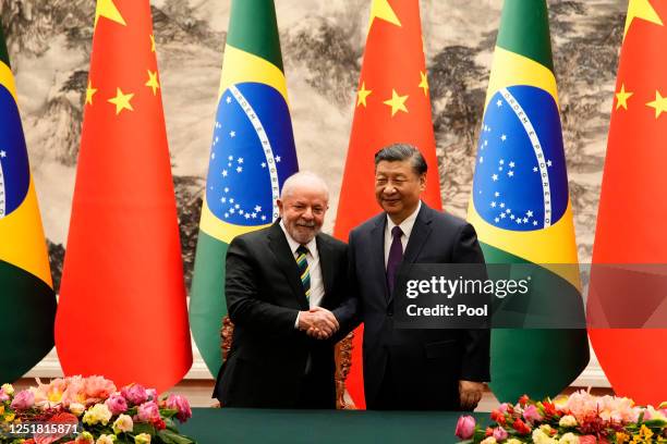 Brazilian President Luiz Inacio Lula da Silva shakes hands with Chinese President Xi Jinping after a signing ceremony held at the Great Hall of the...