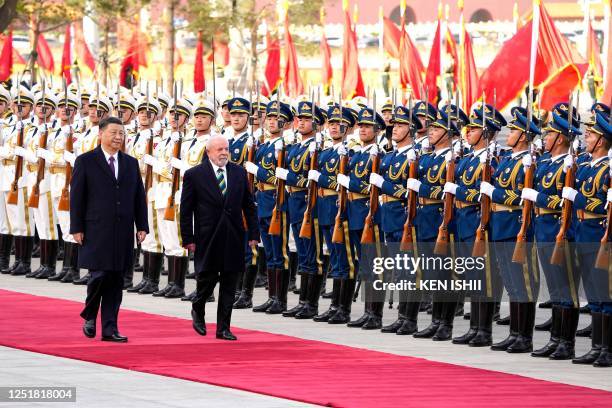 Brazil's President Luiz Inacio Lula da Silva inspects a guard of honour with Chinese President Xi Jinping during a welcome ceremony held at the Great...