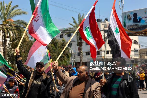Palestinians wave Syrian, Lebanese, Iranian and Egyptian flags during a rally marking Al-Quds Day, a commemoration in support of the Palestinian...