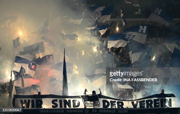 Hertha Berlin supporters wave flags and light flares during the German first division Bundesliga football match between FC Schalke 04 and Hertha...