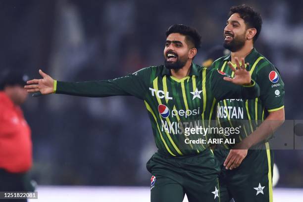 Pakistan's captain Babar Azam and teammates Haris Rauf celebrate after the dismissal of New Zealand's Mark Chapman during the first Twenty20 cricket...