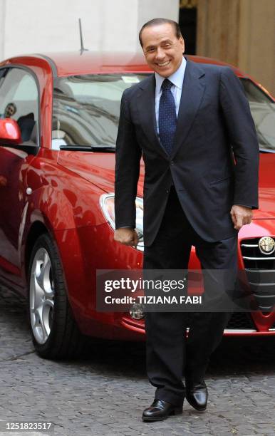 Italian Prime Minister Silvio Berlusconi poses next to the new Alfa Romeo Mito, during the official presentation at Palazzo Chigi in Rome on July 24,...