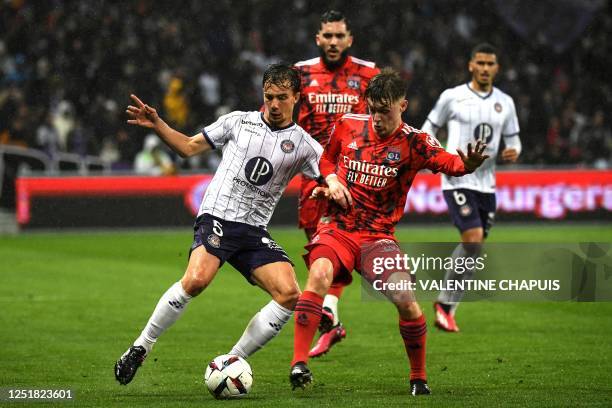 Toulouse's Australian midfielder Denis Genreau fights for the ball with Lyon's French midfielder Johann Lepenant during the French L1 football match...