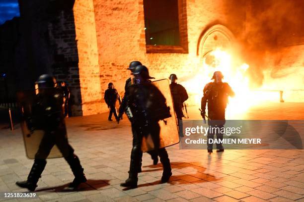 French gendarmes in riot stand guard near a fire at one of the entrances of former Convent of the Jacobins during a demonstration, after France's...