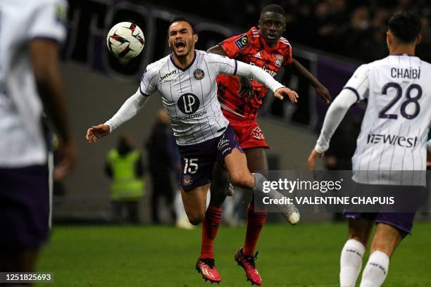 Toulouse's Chilean defender Gabriel Suazo reacts next to Lyon's French defender Sael Kumbedi during the French L1 football match between Toulouse FC...