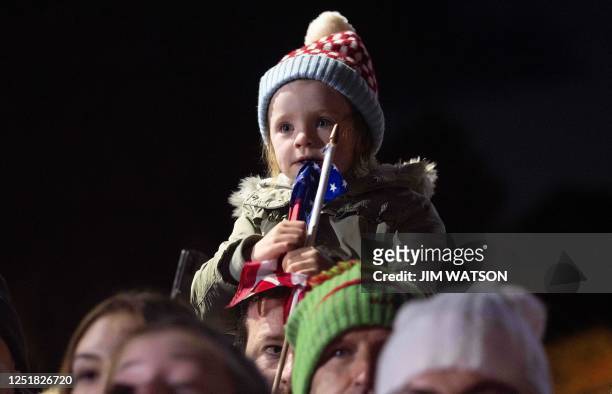 Young child chews a small US flag while waiting for US President Joe Biden to arrive to deliver a speech at Saint Muredach's Cathedral in Ballina, on...