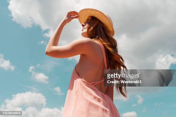 portrait of redheaded woman enjoying sunlight - capelli lunghi foto e immagini stock