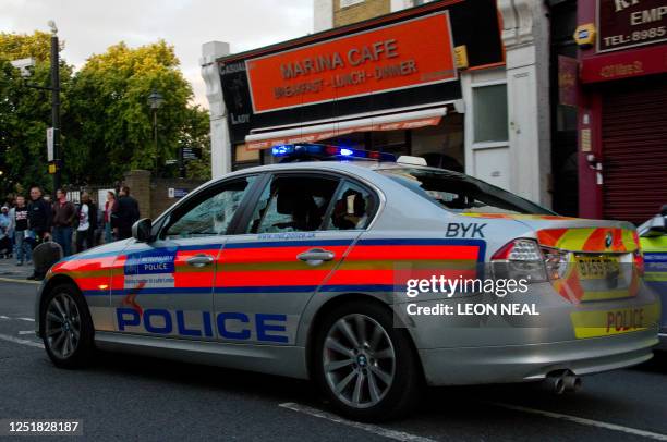 Damaged police car is driven through the police line in Hackney, north London on 8 August 2011. Now in it's third night of unrest, London has seen...