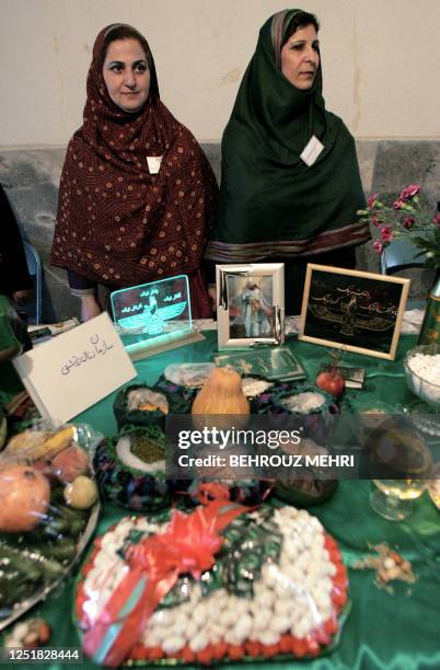 Iranian Zoroastrian women stand in font of traditional offerings during the Mehregan celebrations at the Marcar cultural center in Tehran, 02 October...