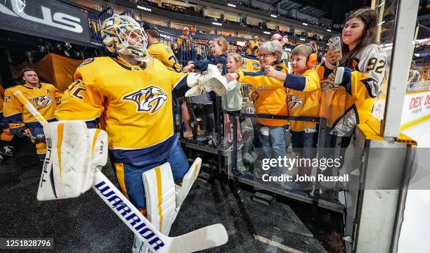 Juuse Saros of the Nashville Predators taps hands with fans as he takes the ice for an NHL game against the Colorado Avalanche at Bridgestone Arena...