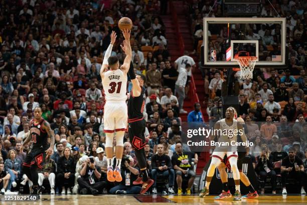 Max Strus of the Miami Heat shoots a three-point shot while being defended by Zach LaVine of the Chicago Bulls at Kaseya Center on April 14, 2023 in...