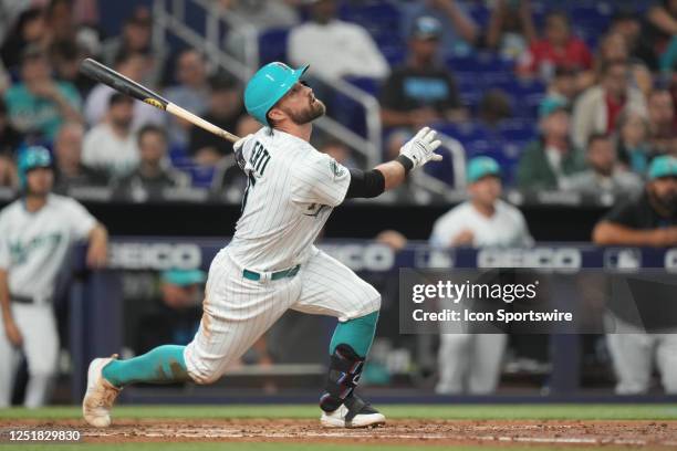 Miami Marlins third baseman Jon Berti watches the ball after making contact at the plate during the game between the Arizona Diamondbacks and the...