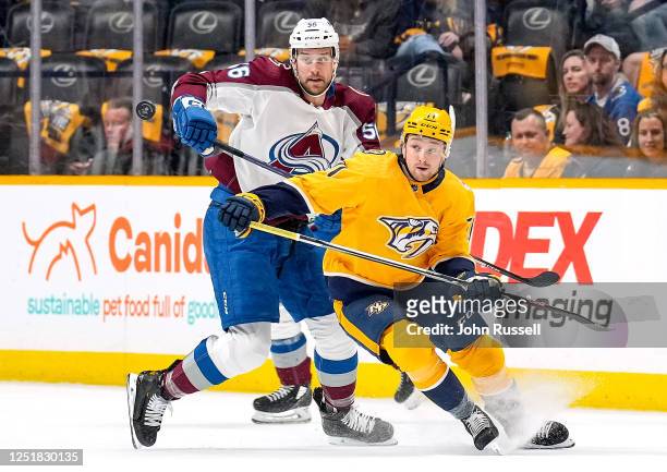 Rasmus Asplund of the Nashville Predators battles for the puck against against Kurtis MacDermid of the Colorado Avalanche during an NHL game at...