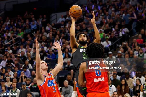 Karl-Anthony Towns of the Minnesota Timberwolves shoots the ball while Josh Giddey and Jaylin Williams of the Oklahoma City Thunder defend in the...