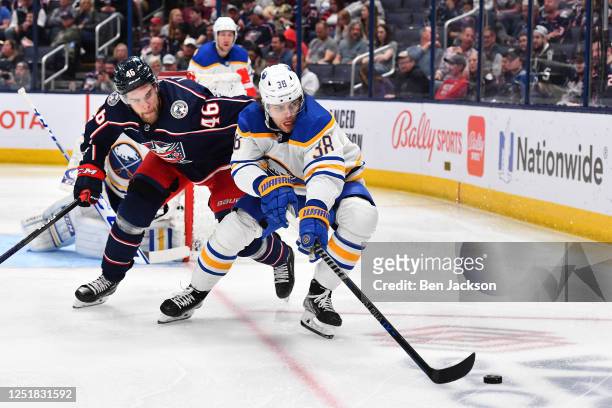 Kale Clague of the Buffalo Sabres battles to keep the puck away from Joona Luoto of the Columbus Blue Jackets during the third period of a game at...