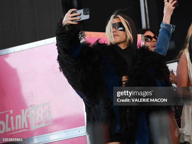 Kourtney Kardashian stands on the side of the stage as her husband Travis Barker performs with his band Blink-182 during the first week-end of...