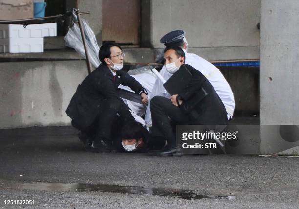 Man is arrested after throwing what appeared to be a smoke bomb in Wakayama on April 15, 2023. - Japanese Prime Minister Fumio Kishida was evacuated...