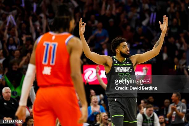 Karl-Anthony Towns of the Minnesota Timberwolves celebrates a basket by teammate Rudy Gobert while Isaiah Joe of the Oklahoma City Thunder looks on...