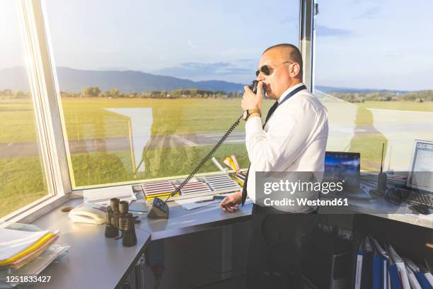 pilot standing in control tower, talking on the radio - airport tower stock pictures, royalty-free photos & images