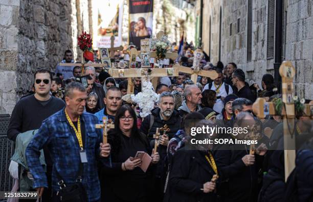 Orthodox Christians carry wooden crosses along the Via Dolorosa in the Old City of Jerusalem during the Orthodox Good Friday procession before Holy...