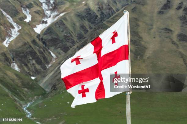 georgia, svaneti, ushguli, georgian national flag fluttering outdoors - georgia caucaso del sud foto e immagini stock